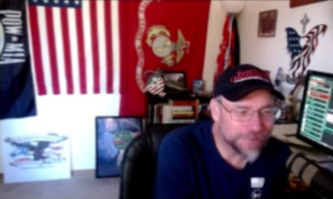 Mark Lamb with host displaying QAnon sign