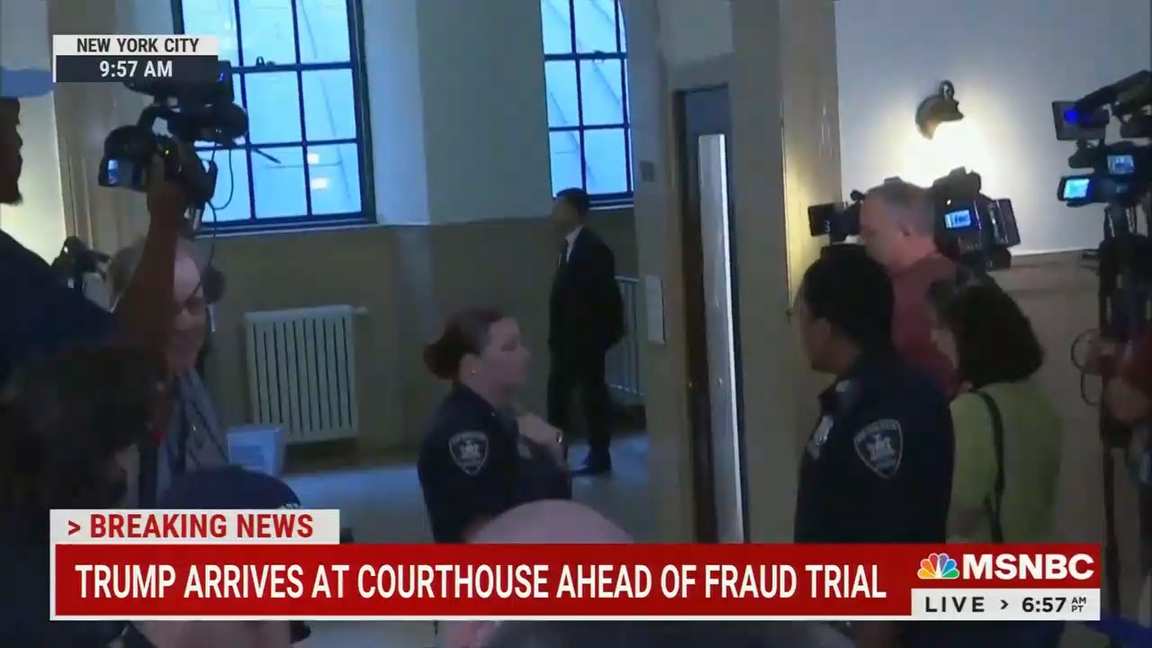 An MSNBC live shot of a courtroom hallway in Manhattan, chyron reads "Breaking News: Trump arrives at courthouse ahead of fraud trial"