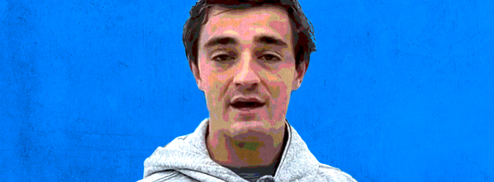 nick shirley in a gray hoodie before a blue background