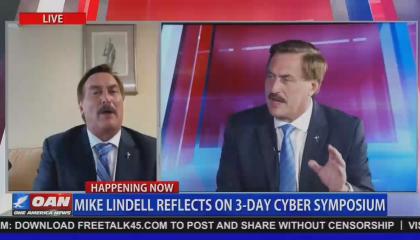 An OAN screenshot of MyPillow CEO Mike Lindell doing a remote interview on screen left, with screen right showing larger file footage of Lindell in a different OAN interview. Chyron reads "Mike Lindell reflects on 3-day Cyber Symposium"