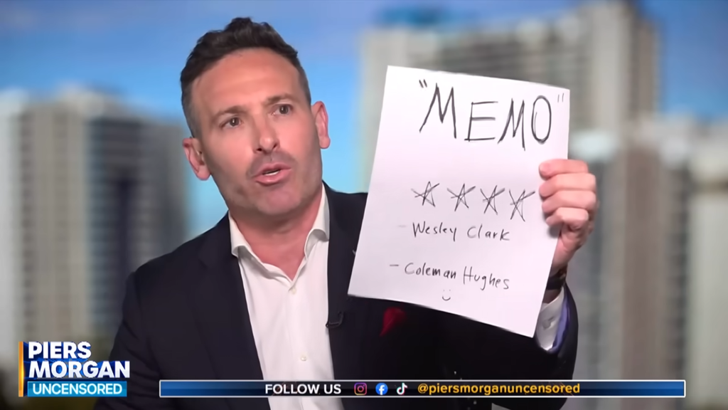 Adam Sosnick holds up prop entitled "Memo" with names of Wesley Clark and Coleman Hughes in Dave Smith debate